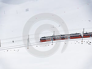 Bright Red Train in Snowy Landscape with Walker, Zermatt Ski Resort Area