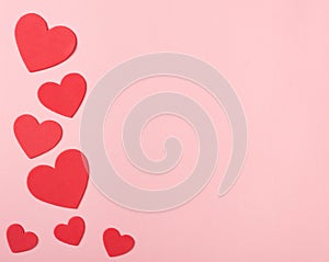 Bright Red Valentine Hearts on Pink Paper with space for copy, text or your words.  It`s a horizontal photo with an above view an
