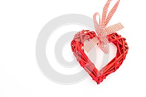 Bright red wicker heart on a solid white background