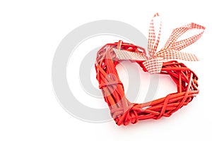 Bright red wicker heart on a solid white background