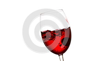 Bright red wine in a tilted glass inside which a splash