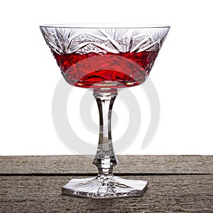 Bright red wine in vintage crystal glass on a white background