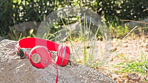 Bright red wired headphones on the rock