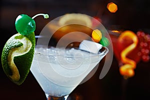 Bright refreshing cocktails: lime daiquiri on a table in a restaurant with creative decoration of lime slices and ice on a wooden