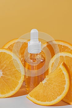 A bright and refreshing display of a Vitamin C serum bottle alongside fresh orange slices on orange background. Skincare