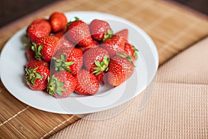 Bright, ripe, delicious strawberries in a white plate