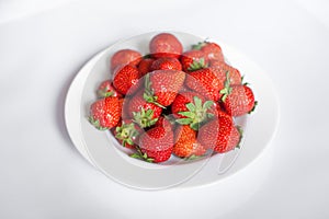 Bright, ripe, delicious strawberries in a white plate