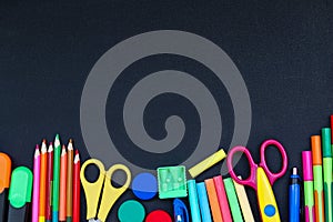 Bright school supplies on blackboard background ready for your design