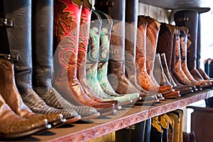 Bright shiny cowboy boots standing on a shelf in craft shop