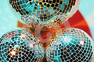 Bright shiny disco balls on color background, top view