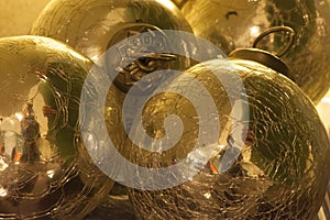 Bright and shiny golden-colored ornaments or balls and viewed in close-up.