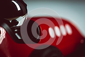 Bright silver helmet on a racing driver on a red toy vintage racing car