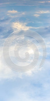 Bright sky with white and blue clouds, vertical format