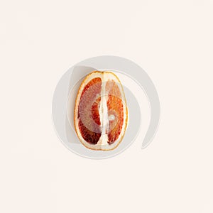 Bright slice citrus fruit, grapefruit or red orange. Summer minimal flat lay. Top view with sunlight.