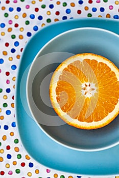 Bright sliced orange lies on blue plates. The composition is on a tablecloth