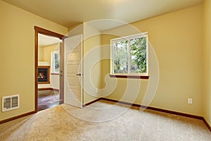 Bright small empty room with carpet floor and ivory walls.