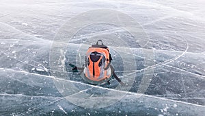 Bright small Hiking backpack lies on the ice of the frozen lake Baikal in Siberia. The journey-the hike in the frosty Russia.