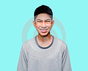 A bright smiling Asian young man looks happy with a mesmerizing expression and is shocked against a blue background. Cheerful men