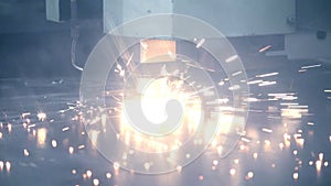 Bright sparks fly during laser metal cutting. Industrial welding in workshop