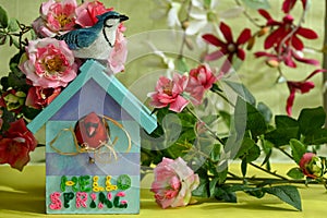 bright spring decoration with birdhouse,birds and artificial flowers.