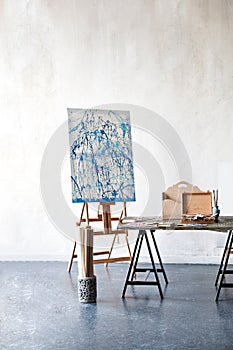 Bright studio of the artist with a gray floor. Workspace of the artist. Easel, canvases and brushes for teaching drawing. Conceptu
