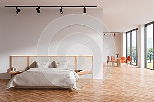 Bright studio room interior with bed, empty white wall