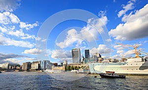A bright summer day on the River Thames with many iconic buildings and a bright blue cloudy sky, London