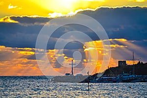 Bright sun above dark clouds over cross at pier Nessebar Old Town Bulgaria