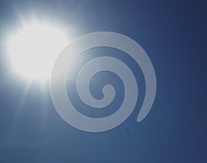 The bright sun with beams in the blue sky