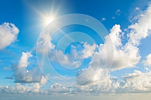 bright sun, blue sky and light clouds