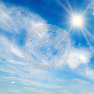 The bright sun, blue sky and light clouds
