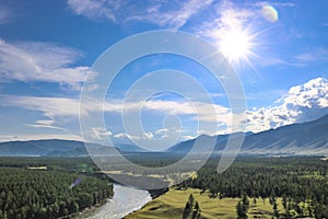 Bright sun, blue sky over the mountain valley and the river. Summer landscape. Good weather