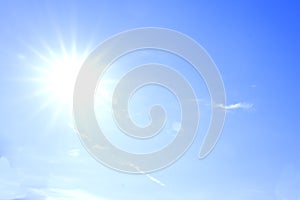 The bright sun on the blue sky. The sun`s rays diverge in different directions.