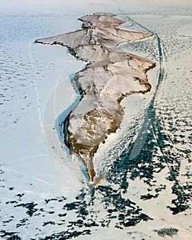Bright sun orange Ogoy Island Sharp dark rock splashes Structure stone ice cracks Lake Baikal Russia coastal. Innocent