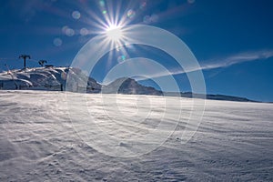 Bright Sun Over the Mountain Slope and Snowy Blizzard