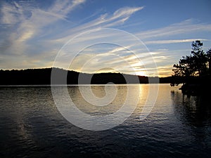 Bright sun setting on the horizon over Baptiste Lake