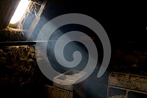 Bright sunlight beam enters an old hay barn