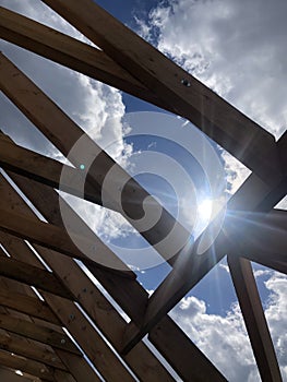 Beautiful sunlight shining through wooden beams on a blue sky background