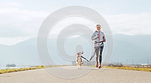 Bright sunny Morning Canicross exercises. Female runs with his beagle dog and happy smiling photo