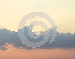 Bright Sunrays from Sun behind Dark Clouds in Evening Sky with Warm Colors - Natural Background