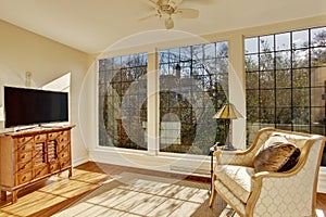 Bright sunroom with antique chair and tv