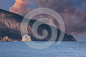 Bright sunset over the sea bay with mountains and rocks in the water. Black Sea. selective focus