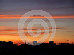Bright sunset sky over the silhouette of the evening city