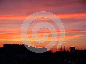 Bright sunset sky over the silhouette of the evening city. Beautiful bright sunset sky over building silhouettes