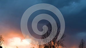 Bright sunset or sunrise on a dark sky with thunderclouds