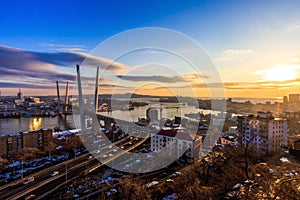 Bright sunset in Vladivostok. Golden Bridge during a colorful sunset. Golden Horn Bay