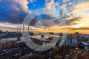 Bright sunset in Vladivostok. Golden Bridge during a colorful sunset. Golden Horn Bay