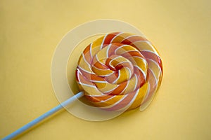 Bright swirl lollipop on yellow background