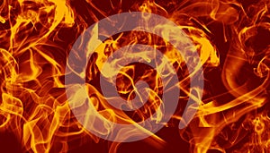 Bright swirling orange flames in motion on a deep red background backdrop.