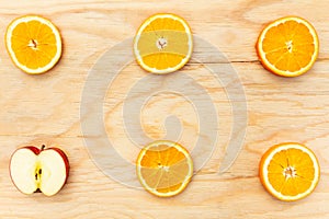 Bright, tasty, fresh, juicy orange slices with an apple slice on wooden background, natural vegan food, good for